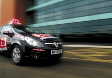 RED black car driving pass glass building