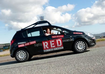 Woman smiling with thumbs up in RED car