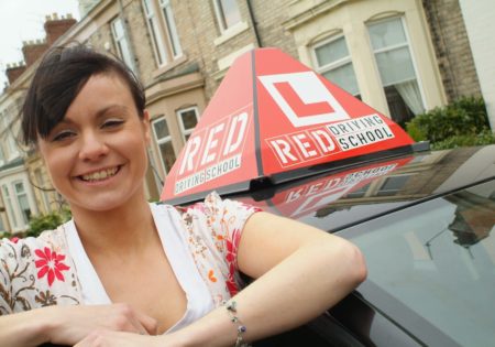 Woman and RED driving school car